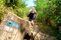 Blue sign for hiking tourism in the Czech Republic. Mark painted on the tree stump. Blurred walking tourists on the path in the