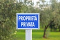 Blue sign with the inscription Private property in Italian outdoor in olive grove