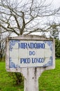 Blue sign Miradoiro do Pico Longo, Viewpoint Pico Longo in English, on typical Portuguese tiles. Grass and trees without