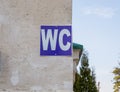 Blue sign of public toilets WC on a stone wall