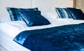 Blue silky hotel room bedding pillows and sheets on bed. Royalty Free Stock Photo
