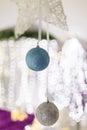 Blue and silver baubles hanging on unfocused background with shiny sparkling garland lights and bokeh. Christmas tree toys Royalty Free Stock Photo