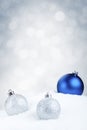 Blue and silver Christmas baubles on snow, silver background Royalty Free Stock Photo