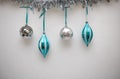 Blue and Silver Christmas Ornaments hanging with a White Background