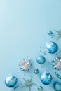 Blue and silver Christmas ornaments scattered on light blue background. Flat lay, top view, vertical Royalty Free Stock Photo