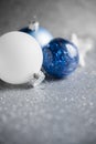 Blue, silver and white xmas ornaments on glitter holiday background. Merry christmas card. Royalty Free Stock Photo