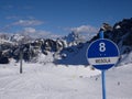 Blue ski slope sign, lift and mountains background in italian dolomites