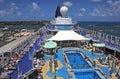 Luxury cruise ship pulls into harbour as passengers still relax on the main deck.