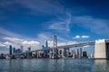 Blue skies over the San Francisco skyline and the bay bridge crossing in front of the Salesforce Tower Royalty Free Stock Photo