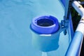 The blue skimmer for cleaning the pool in clear water. Close-up of the skimmer mounted on a frame pool, Control Royalty Free Stock Photo