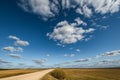 Blue sky background with big white striped clouds in field with gravel road. . blue sky panorama may use for sky replacement Royalty Free Stock Photo