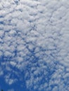 Blue sky background with clouds. Cirro-cumulus clouds on a blue sky on a sunny day. Cirrus sky. Spindrift clouds.