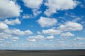 Blue sky background with soft silky clouds and field.