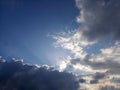 Blue sky background with the sun and rays behind the clouds. Sky heaven. Royalty Free Stock Photo