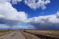 Blue sky background with thunderclouds and country road. Blue, white pastel paradise, soft focus lenses, glare of sunlight. Royalty Free Stock Photo