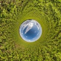 Blue sky ball in middle of swirling asphalt road or field. Inversion of tiny planet transformation of spherical panorama 360