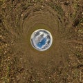 Blue sky ball in middle of swirling field. Inversion of tiny planet transformation of spherical panorama 360 degrees. Curvature of