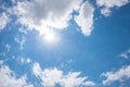 blue sky with bright sun and rays, white cumulus clouds around Royalty Free Stock Photo