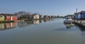 A blue sky and blue canal lined with traditional oysters wooden houses