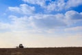 blue sky clouds above dark ploughed field seeder in spring Royalty Free Stock Photo