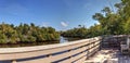 Blue sky and clouds over a bridge that crosses Henderson Creek, which runs through Rookery Bay