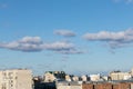 blue sky with clouds over roofs of city illuminated by day sun Royalty Free Stock Photo