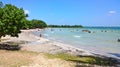 Blue sky and clouds over a tropical beach with green trees in Playa Larga, Cuba. Royalty Free Stock Photo