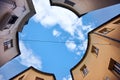 Blue sky with clouds seen from the ground with buildings forming a circle Royalty Free Stock Photo