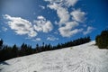 Blue sky with clouds and snow during spring time skiing
