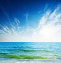 Blue sky with clouds and sun over sea Royalty Free Stock Photo