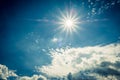 Blue sky with clouds and sun reflection. Sun shines bright in the daytime in summer Royalty Free Stock Photo