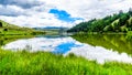 Blue Sky, Clouds and surrounding Mountains reflecting on the smooth water surface of Trapp Lake Royalty Free Stock Photo