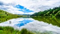 Blue Sky, Clouds and surrounding Mountains reflecting on the smooth water surface of Trapp Lake Royalty Free Stock Photo