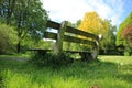 Blue sky with clouds, a wooden bench and trees in the park in spring. Royalty Free Stock Photo