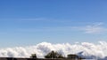 Blue sky with cloudy on the below of the picture with mountain and trees.