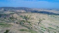Aerial view of farm field hills, terraced valley with massive agricutlure