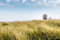 Blue sky and dunes with grass in front of the life saving building in Provincetown Royalty Free Stock Photo