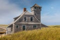 Blue sky and dunes with grass in front of the life saving station building in Provincetown Royalty Free Stock Photo