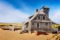 Blue sky and dunes with grass in front of the life saving station building in Provincetown Royalty Free Stock Photo