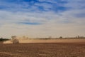 blue sky fleecy clouds above field tractor in great dust cloud Royalty Free Stock Photo