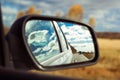 Blue sky with fluffy clouds and road reflection an car mirror Royalty Free Stock Photo