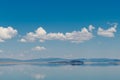 Blue sky with fluffy white clouds reflected in the perfectly still blue waters of Mono Lake, California Royalty Free Stock Photo