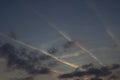 Blue sky with grey dark and white clouds and chem trails