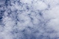 Blue sky invaded by small white clouds background