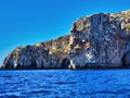 Blue sky with large white clouds. Rock sea nature. Summer vacation. Northern coast grottos and rocks seen by boat. Rocky sea view