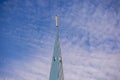 Blue sky with light white small clouds and basilica tower with golden cross and crow on it on blue sky background Royalty Free Stock Photo