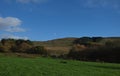 Blue sky looking over field, green grass on hill side, minimal clouds, photo taken in the UK Royalty Free Stock Photo