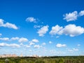 Blue sky with many white clouds over wood and city Royalty Free Stock Photo
