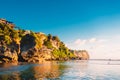 Blue sky, ocean and rocky cliff in Uluwatu, Bali and sunset light