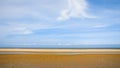 Blue sky over wet yellow sand beach Le Touquet